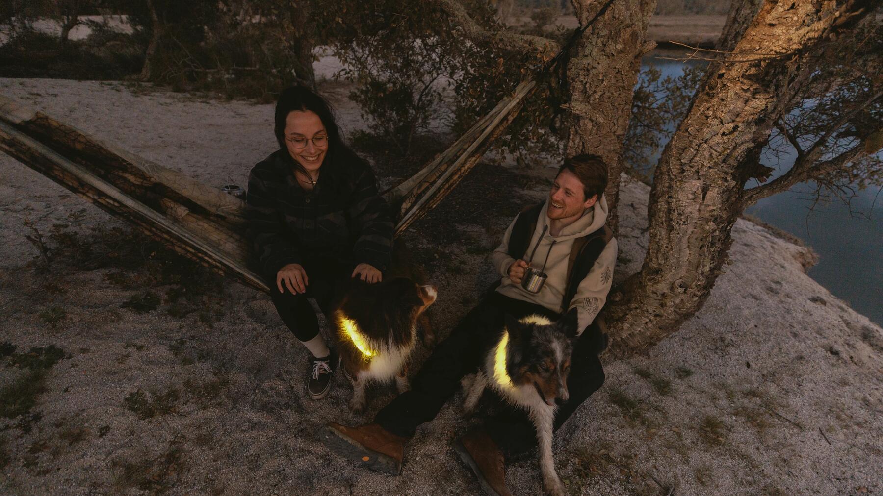 Ein Pärrchen macht beim Wandern mit dem Hund eine Pause in einer Hängematte