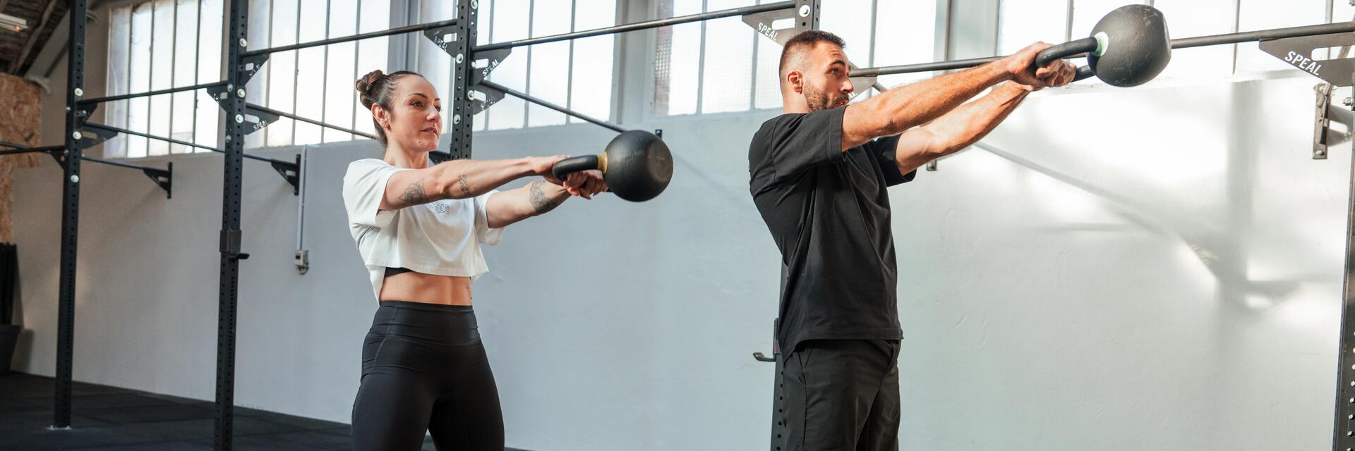 Para ćwicząca z kettlebellem na siłowni