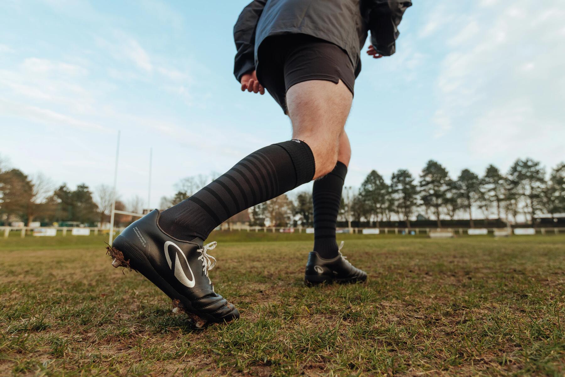 Rugby speler op het veld, je ziet de schoenen, sokken en onderlichaam
