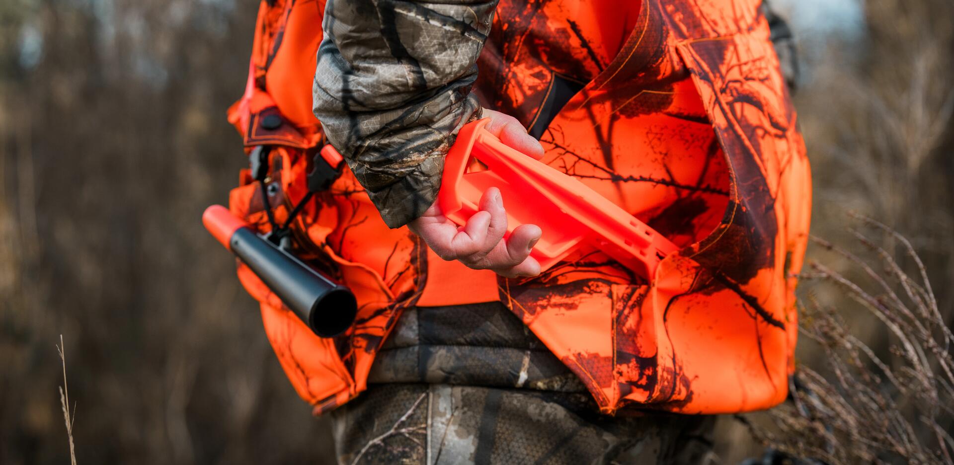Un chasseur prend ses piquets de battue dans le carnier de sa veste
