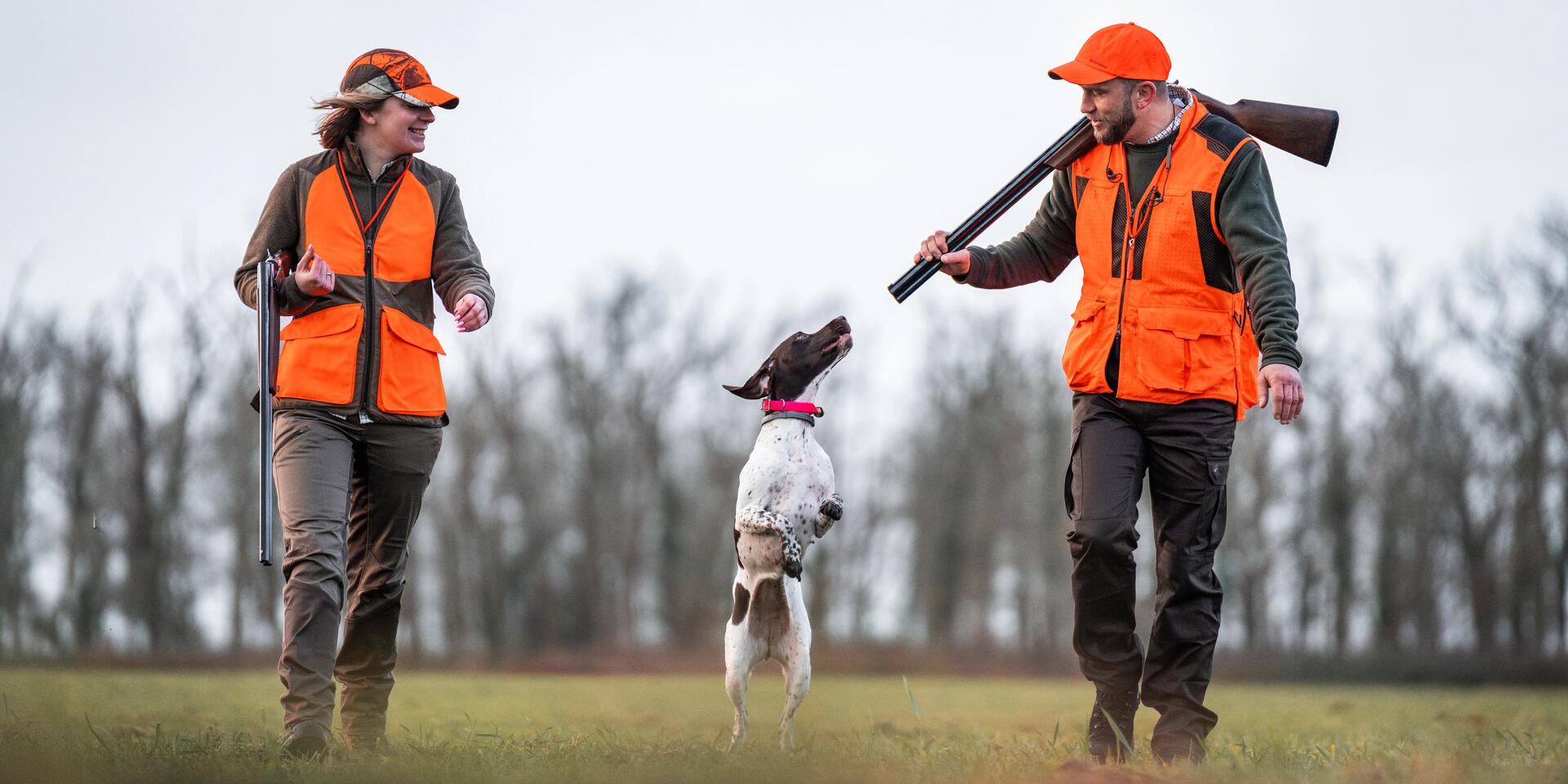 Un chasseur et une chasseresse partant à la chasse avec leur chien