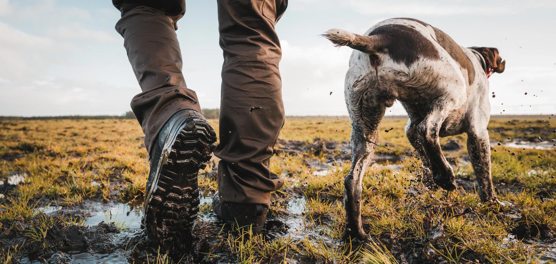 Un chasseur avec les chaussures crosshunt 120 Solognac aux pieds dans une champ détrempé