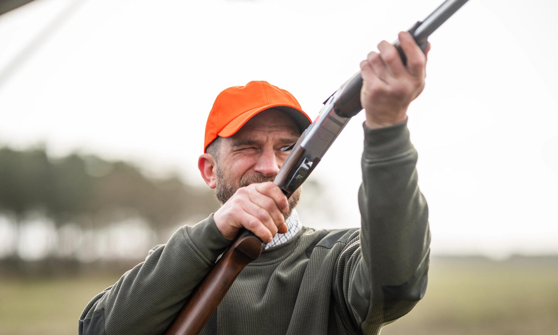 Un chasseur vérifiant l'état des canons de son arme avant de partir chasser