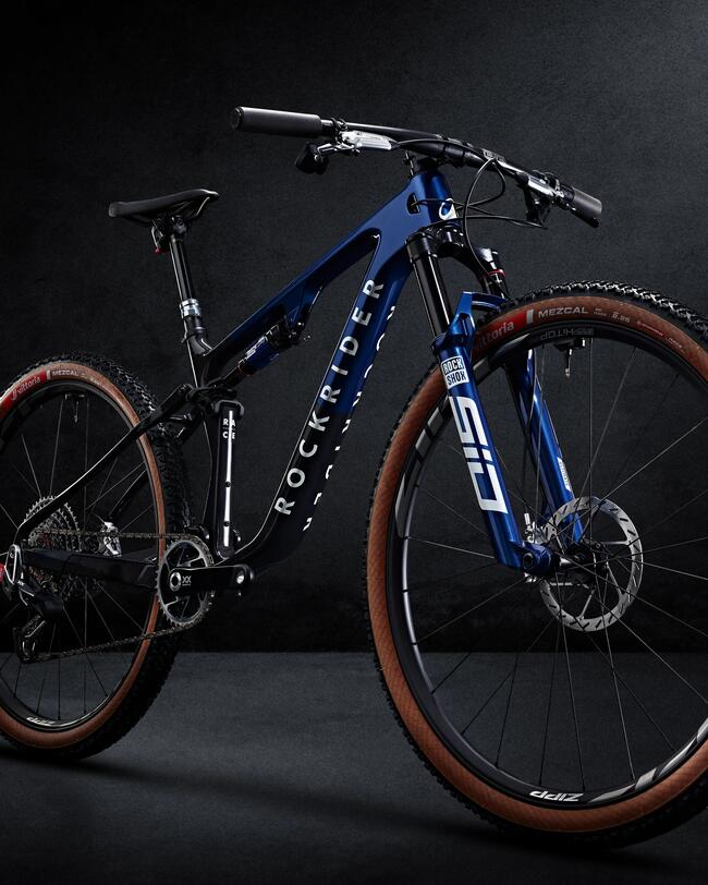 Dunkleblaues sportliches Mountainbike vor dunklem Hintergrund