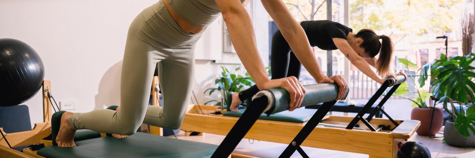 Kobiety w odzieży do pilatesu trenujące pilates na reformerach