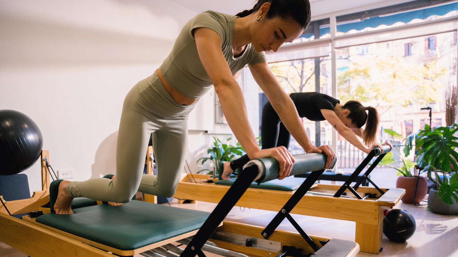Kobiety w odzieży do pilatesu trenujące pilates na reformerach
