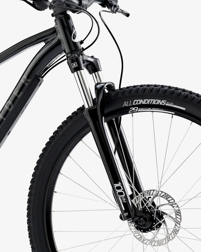 Mann mit gelber Hose fährt auf schwarzem Fahrrad Waldweg entlang