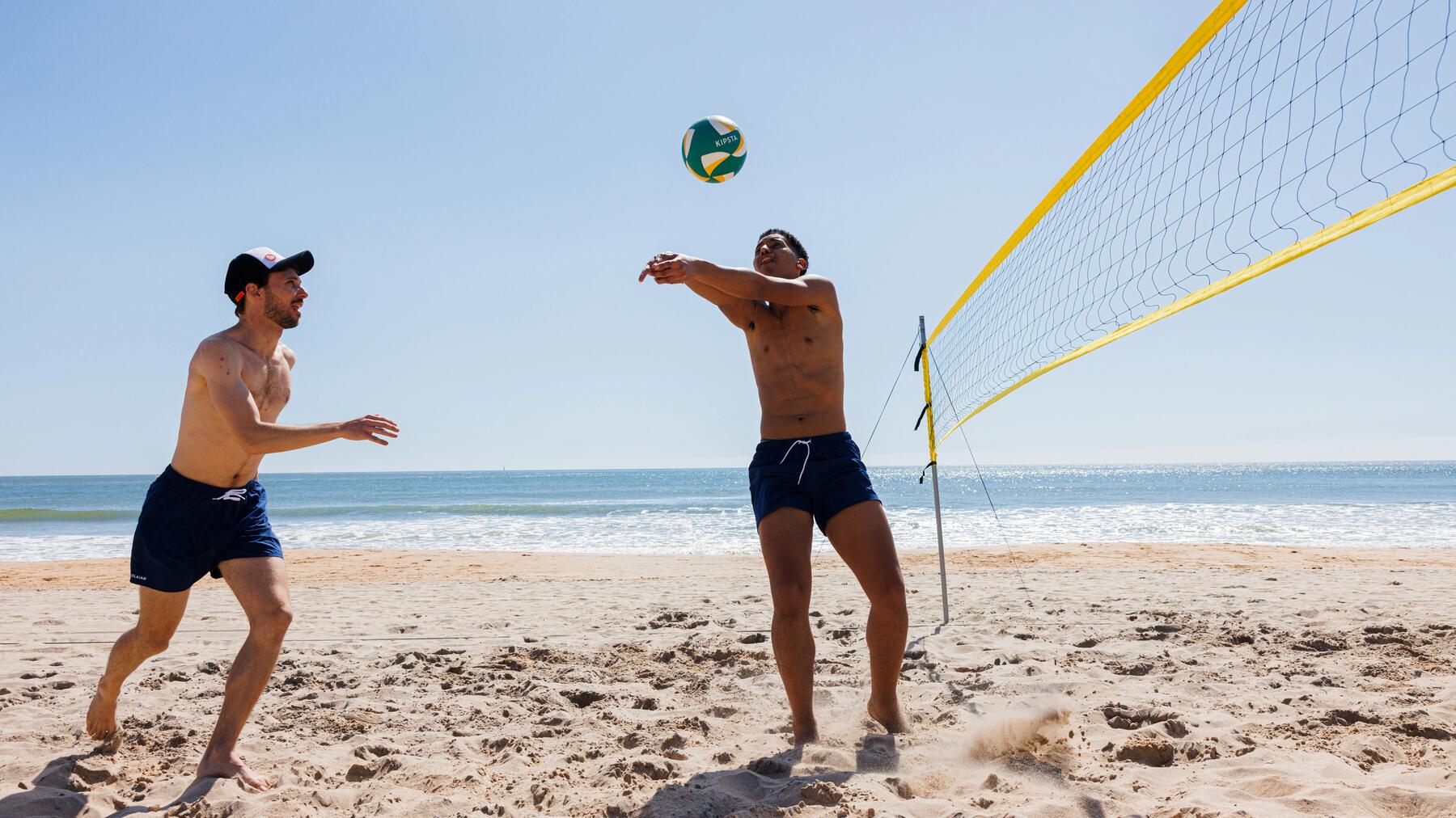 Zwei Freunde spielen am Beachvolleyballnetz