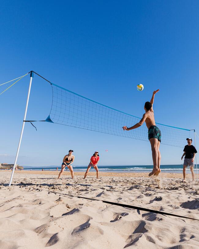 Strandvolleyballnetz-Set mit Netz, Pfosten, Feldlinien, stabiler Verankerung; Spielen am sonnigen Sandstrand unter blauem Himmel.