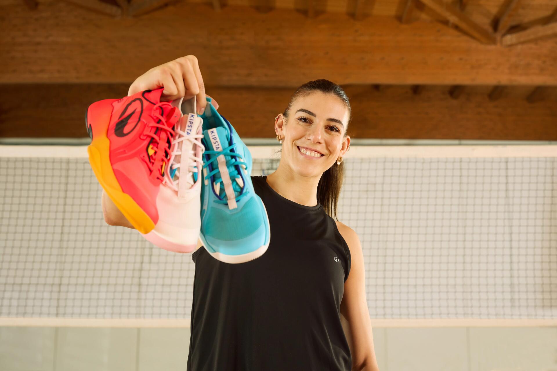 Kobieta w odzieży sportowej trzymająca buty w różnych kolorach