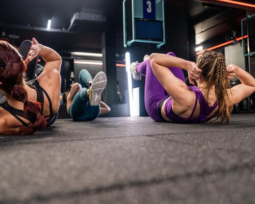 Kobiety w odzieży sportowej ćwiczące rowerek na podłodze