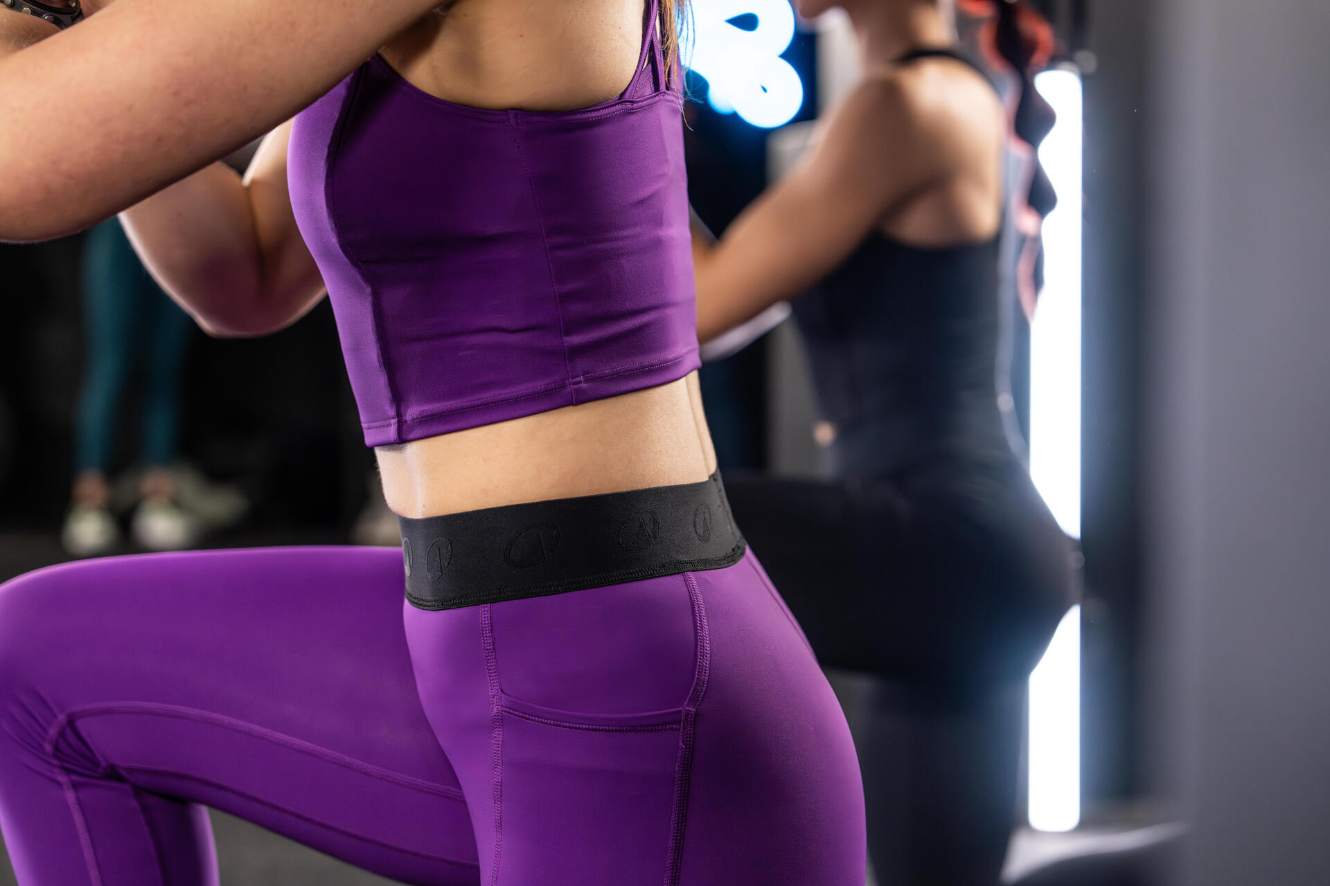 Kobiety w strojach sportowych ćwiczące wykroki na siłowni