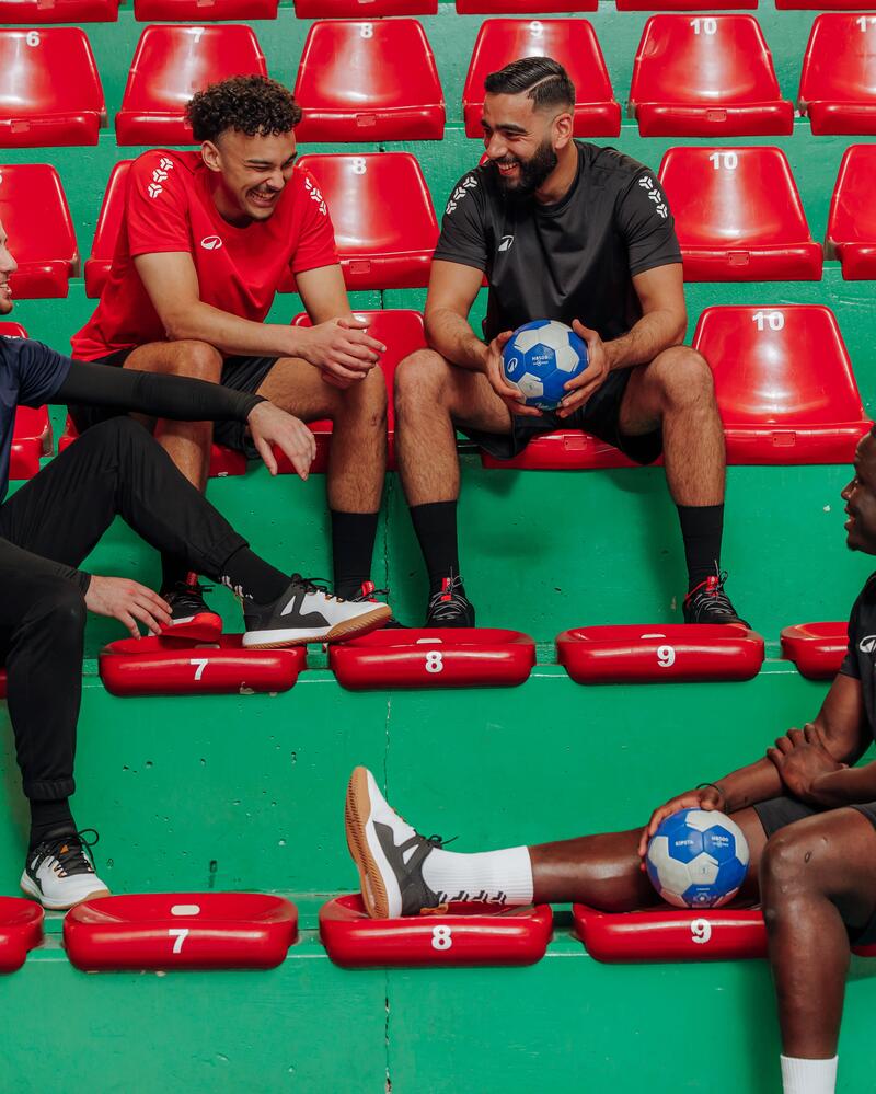 Zwei Männer sitzen auf der Bank mit einem Handball