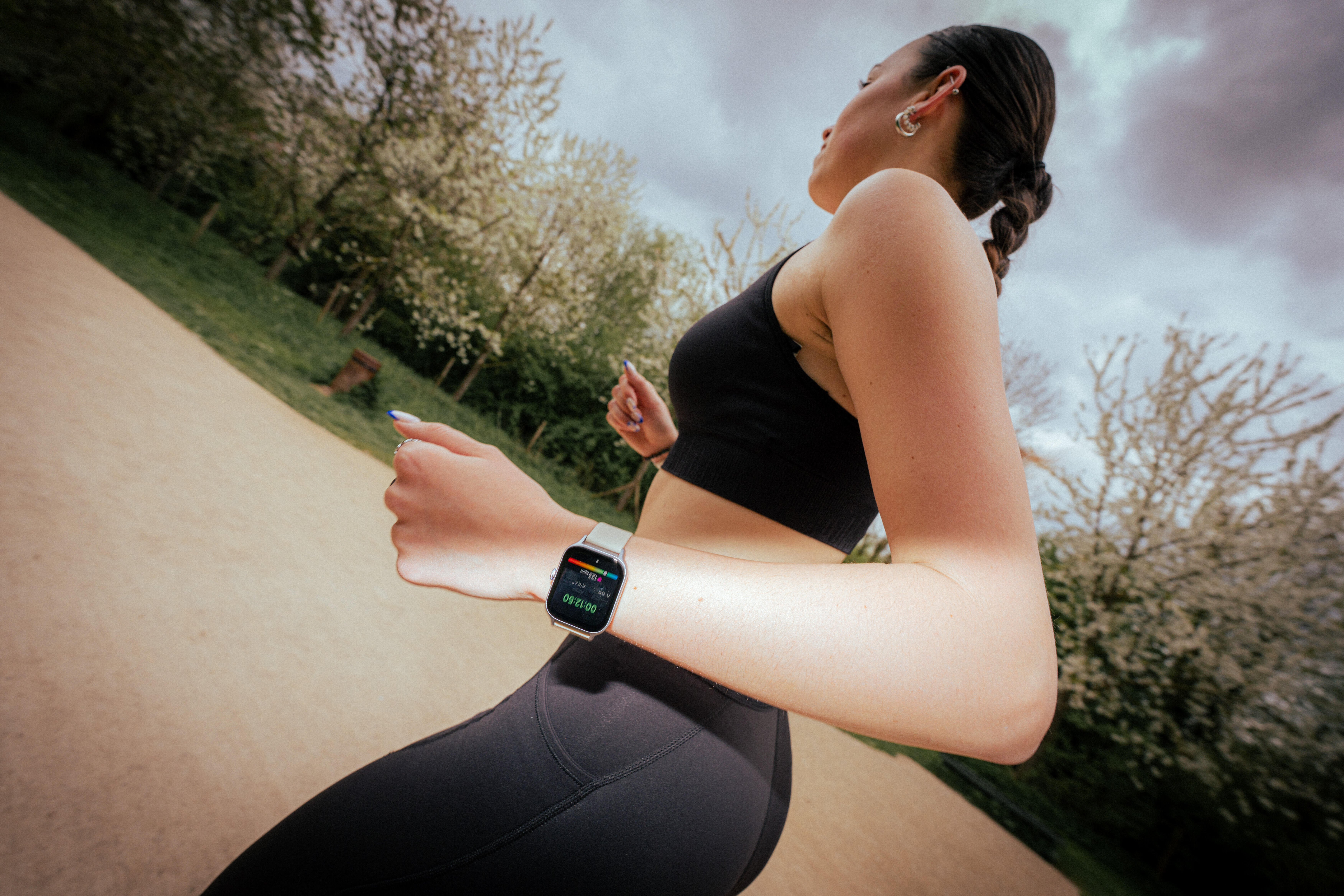 Woman running outdoors while wearing a fitness watch