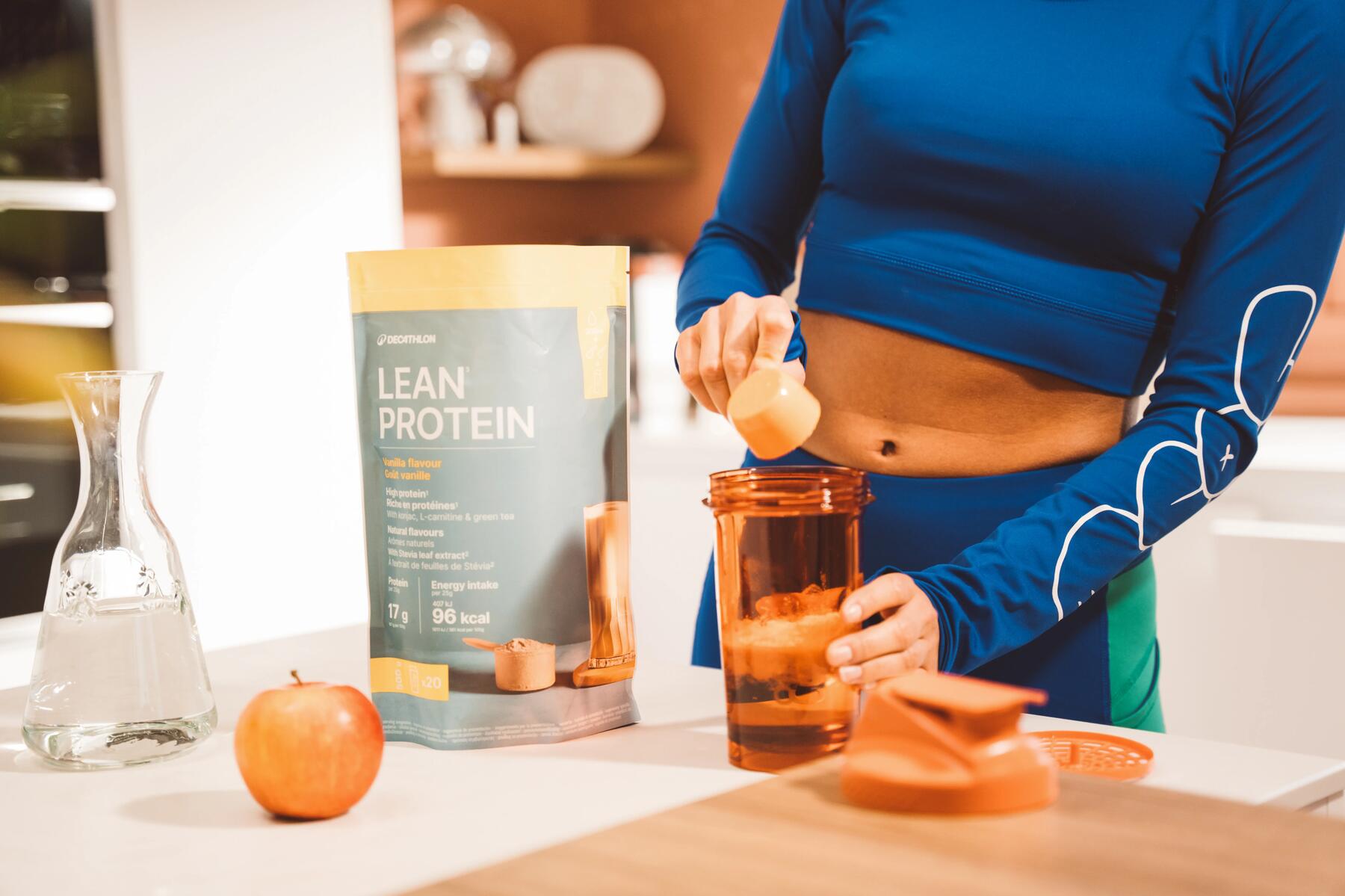 Frau in blauer Sportkleidung beim Mischen von Proteinshake