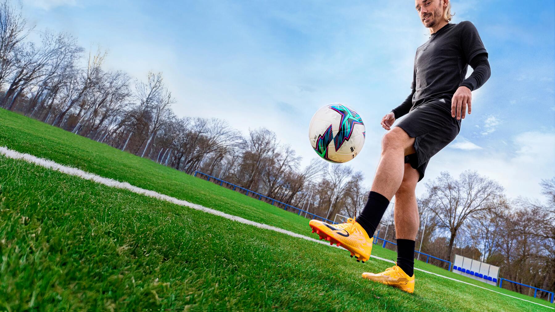 Eine Mann kickt einen Ball mit Fußballschuhen
