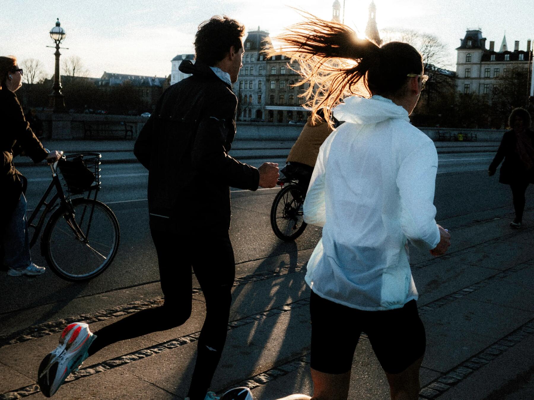 Man en vrouw samen aan het hardlopen over de weg