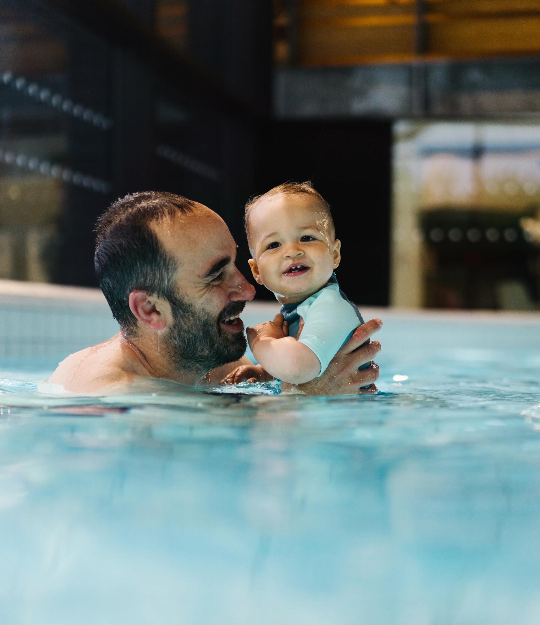 hombre enseñando a nadar a un bebe