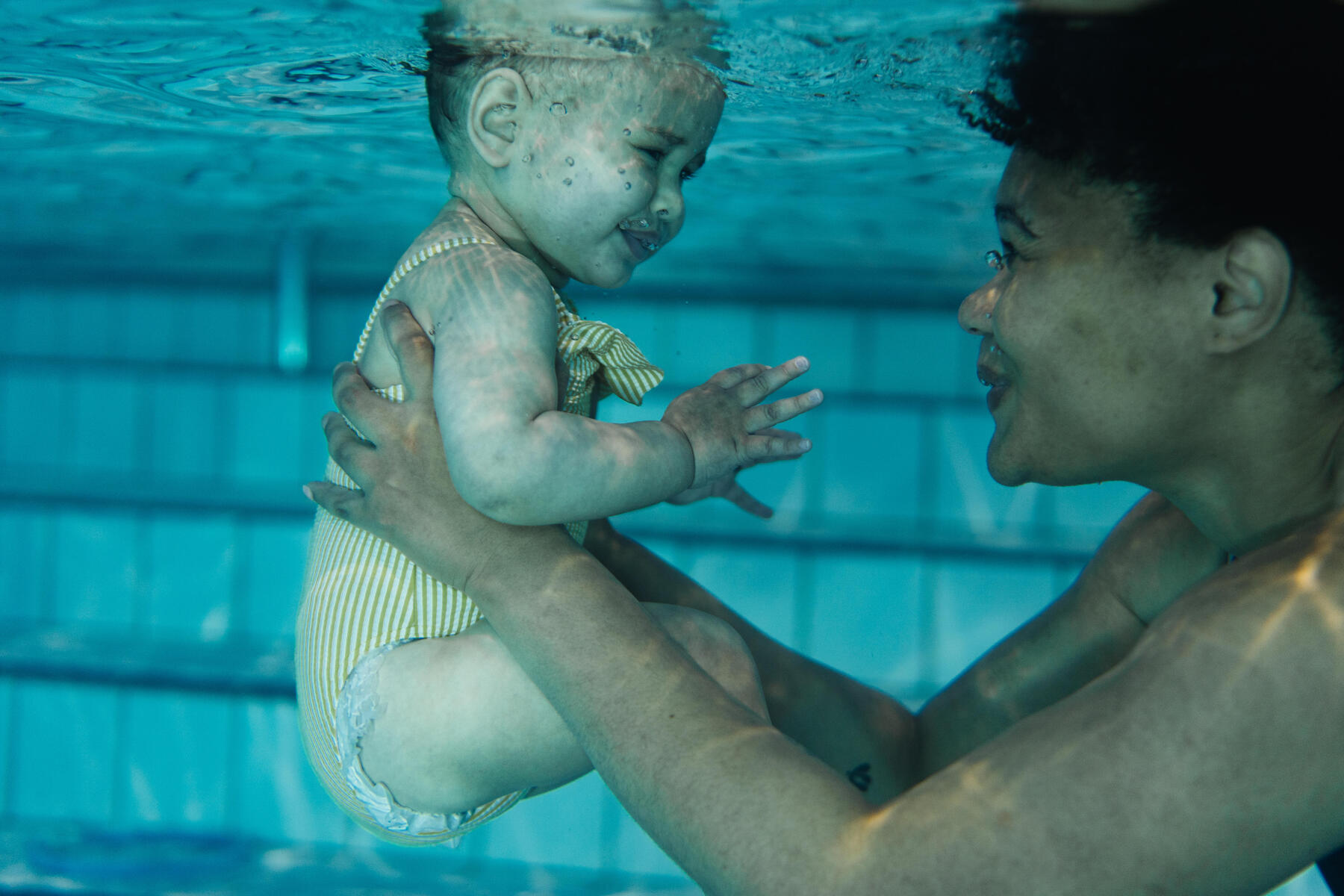 Mama z dziewczynką pod wodą patrzące na siebie