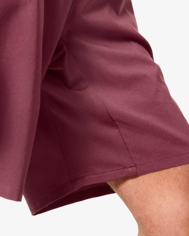 Nahaufnahme des Saums einer weinroten Sporthose mit seitlichem Mesh-Einsatz.