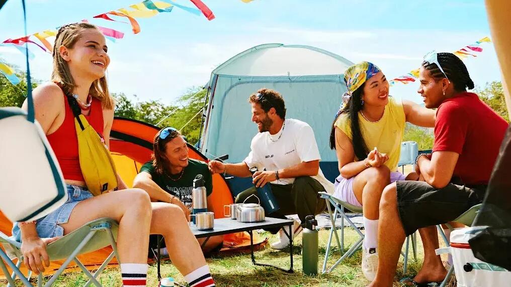 Bunter Campingplatz auf einem Festival mit Zelten, Pavillons und Campingstühlen
