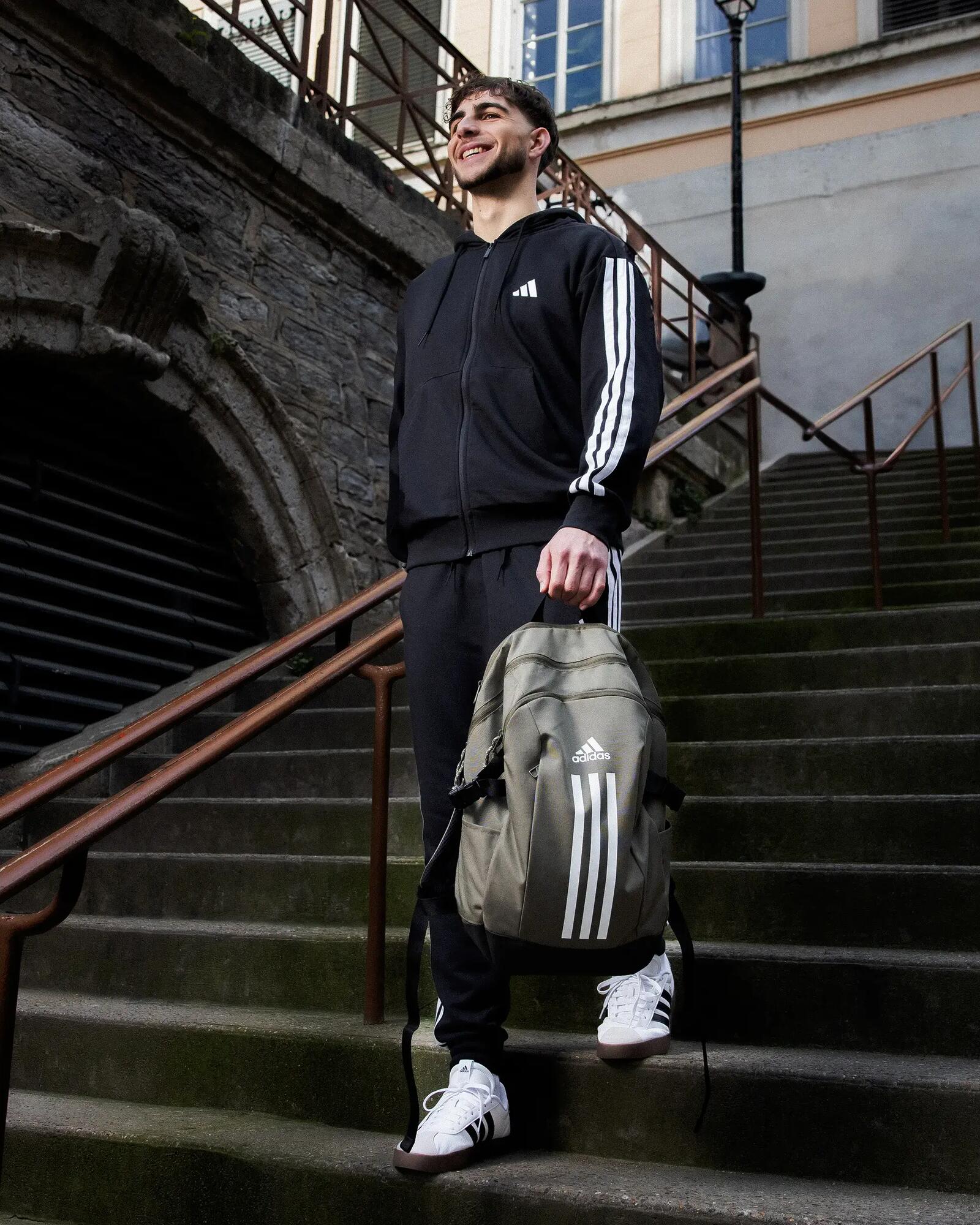 Mann in Trainingsanzug mir Rucksack in der hand