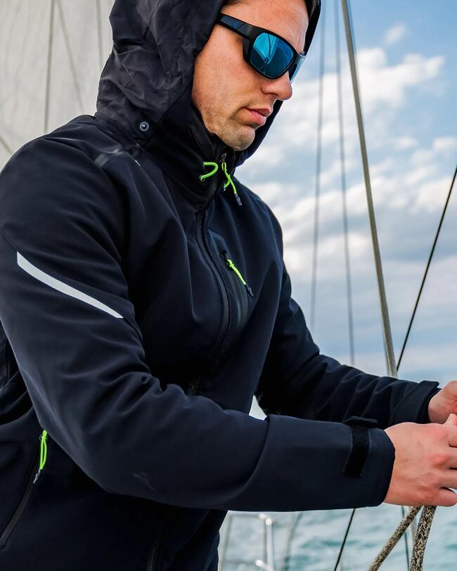 marin sur un bateau, en veste softshell noire