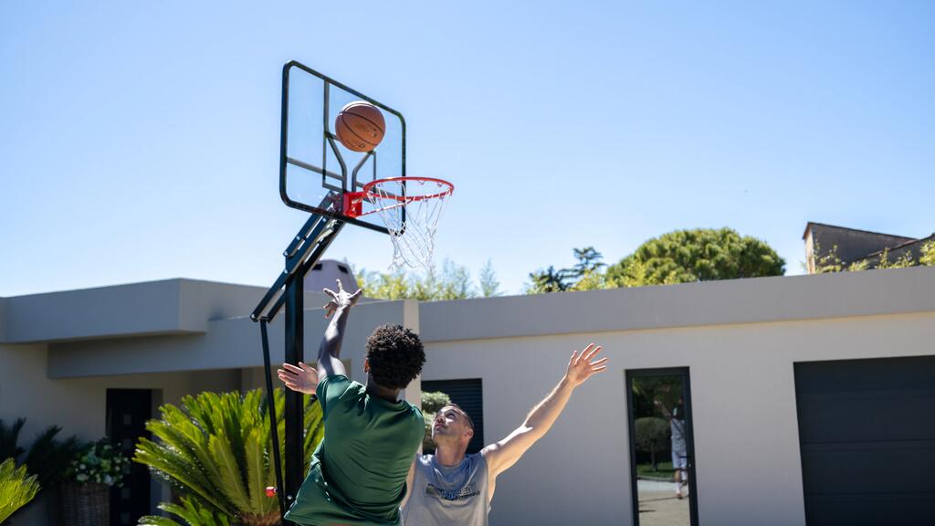 Zwei Männer spielen Basketball mi einem Tarmak Ball und einem Tarmak B700 Basketballkorb.