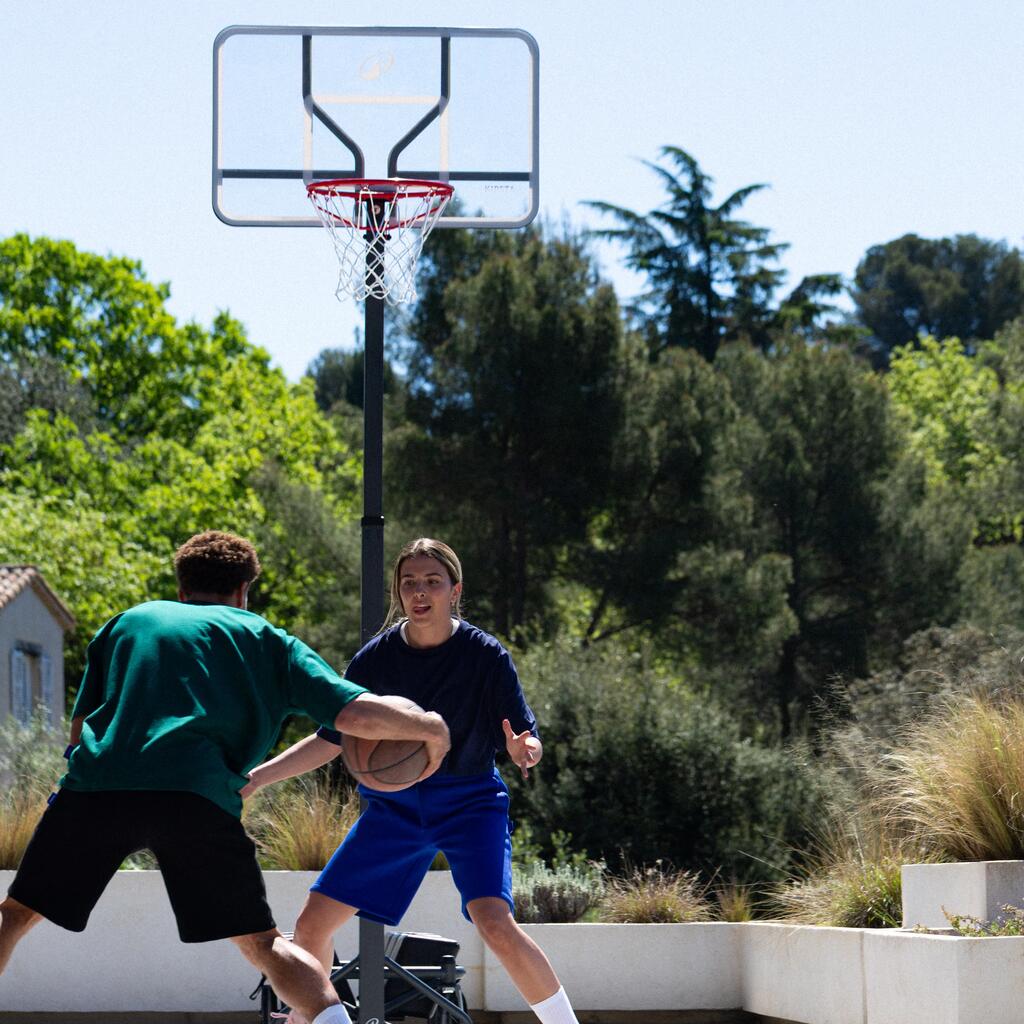 Dečak i devojčica igraju košarku u dvorištu