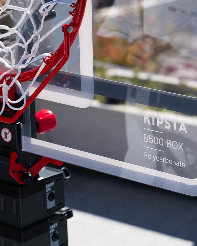Roter Basketballkorb, weißes Netz, blauer Himmel, Szenerie mit klaren Linien und sportlichem Flair.
