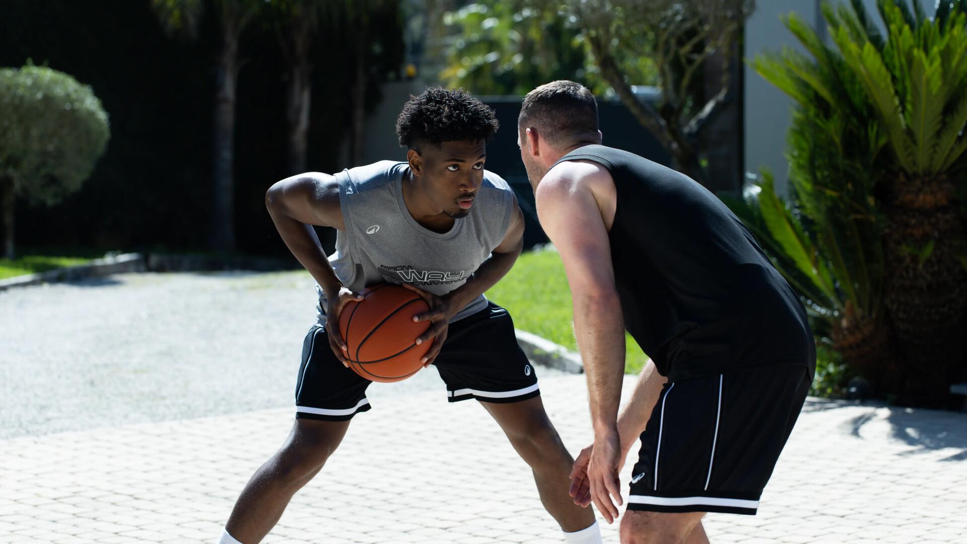 3 jeunes enfants qui pratique le basketball dans un gymnase