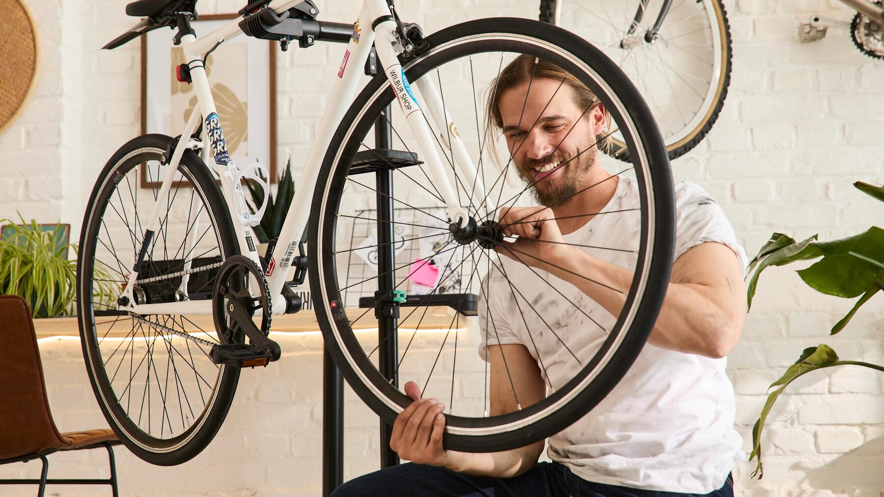 homem a fazer manutenção na roda da bicicleta