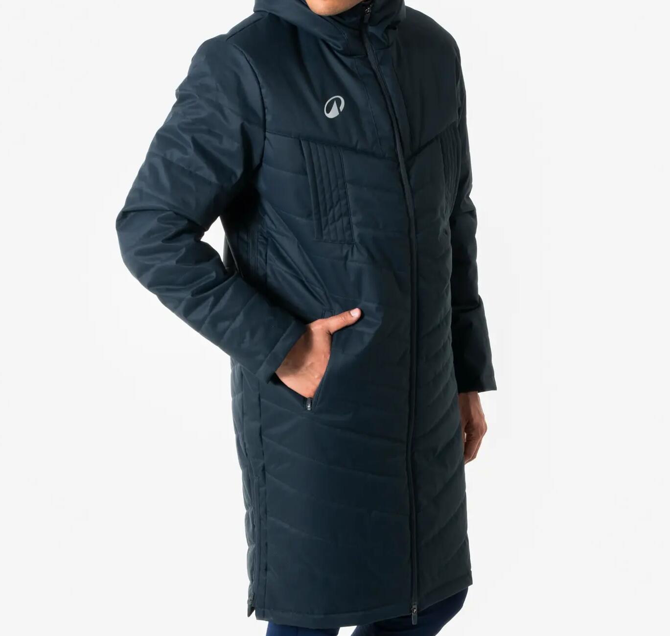 Mann in schwarzem Parka vor weißer Wand.
