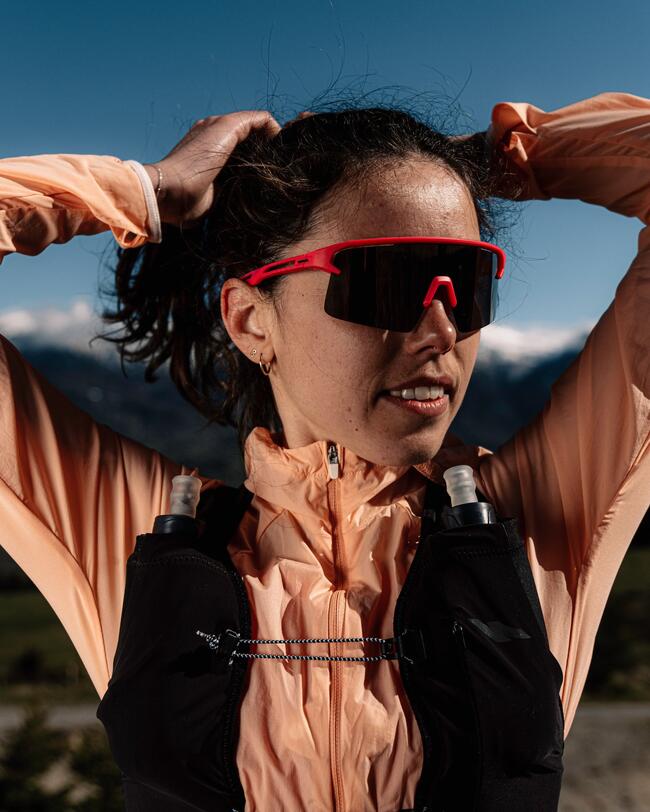 Eine Trailrunnerin mit Sportbrille und Laufweste..