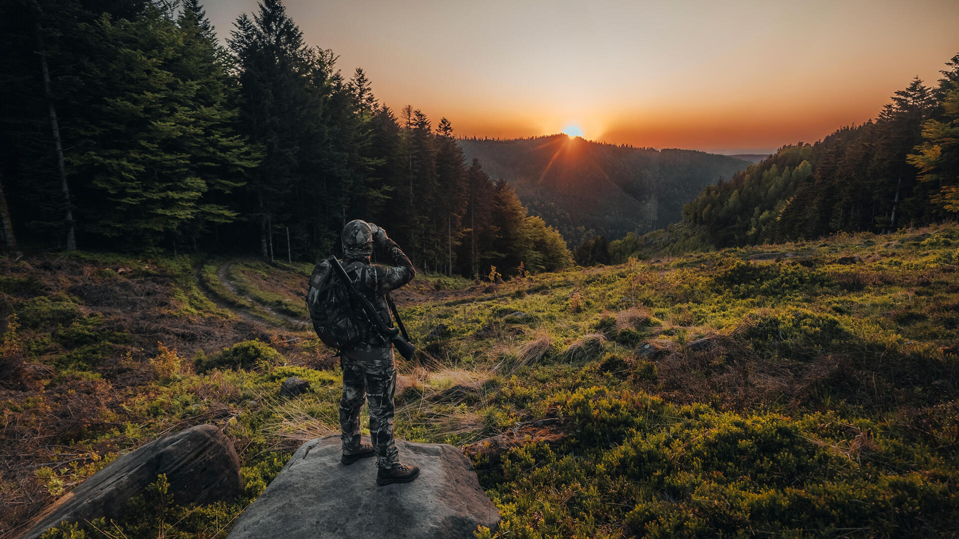 Un chasseur avec une paire de jumelles HTR dans les mains