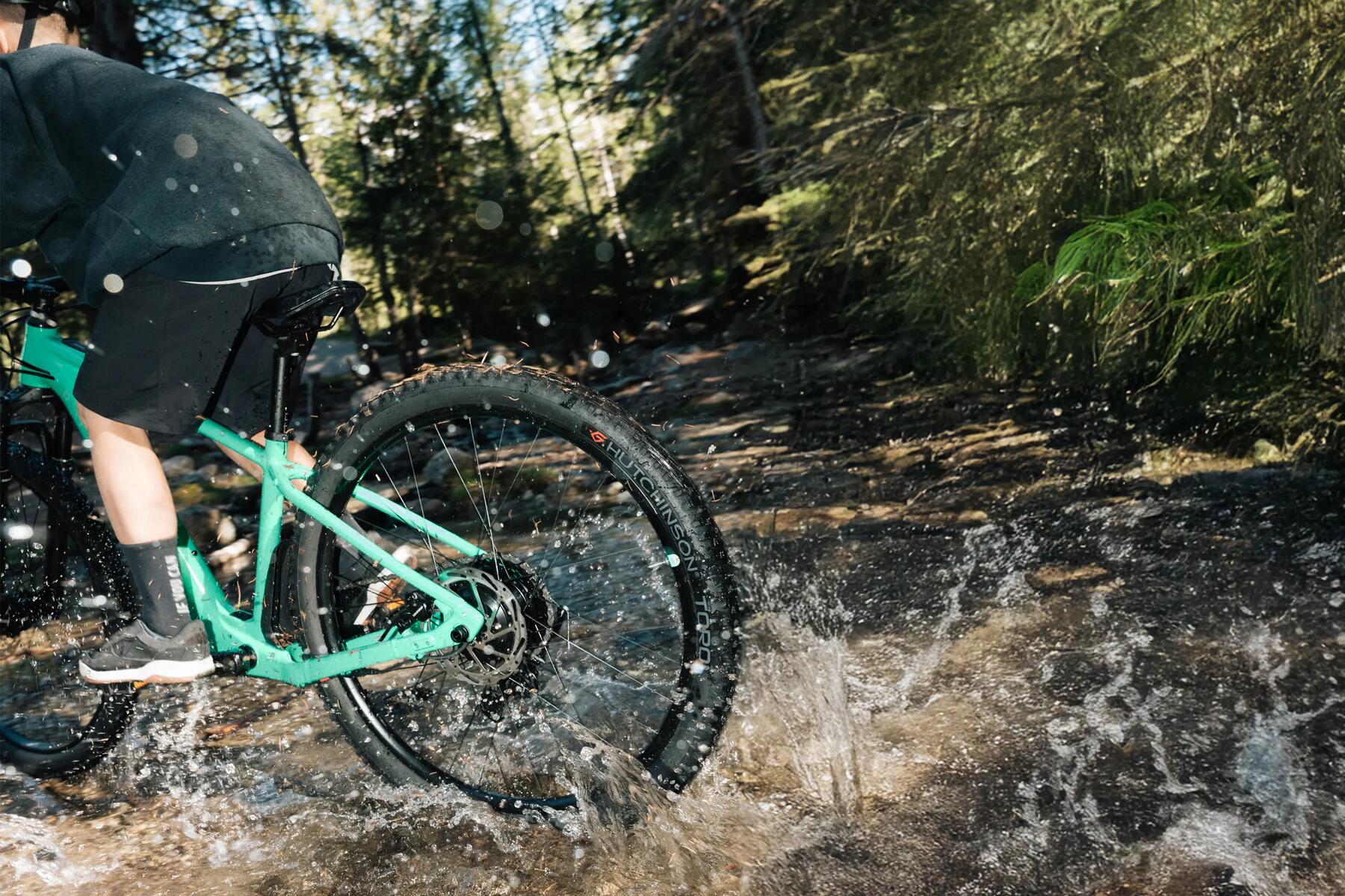 Junge fährt mit dem Fahrrad durch Wasser