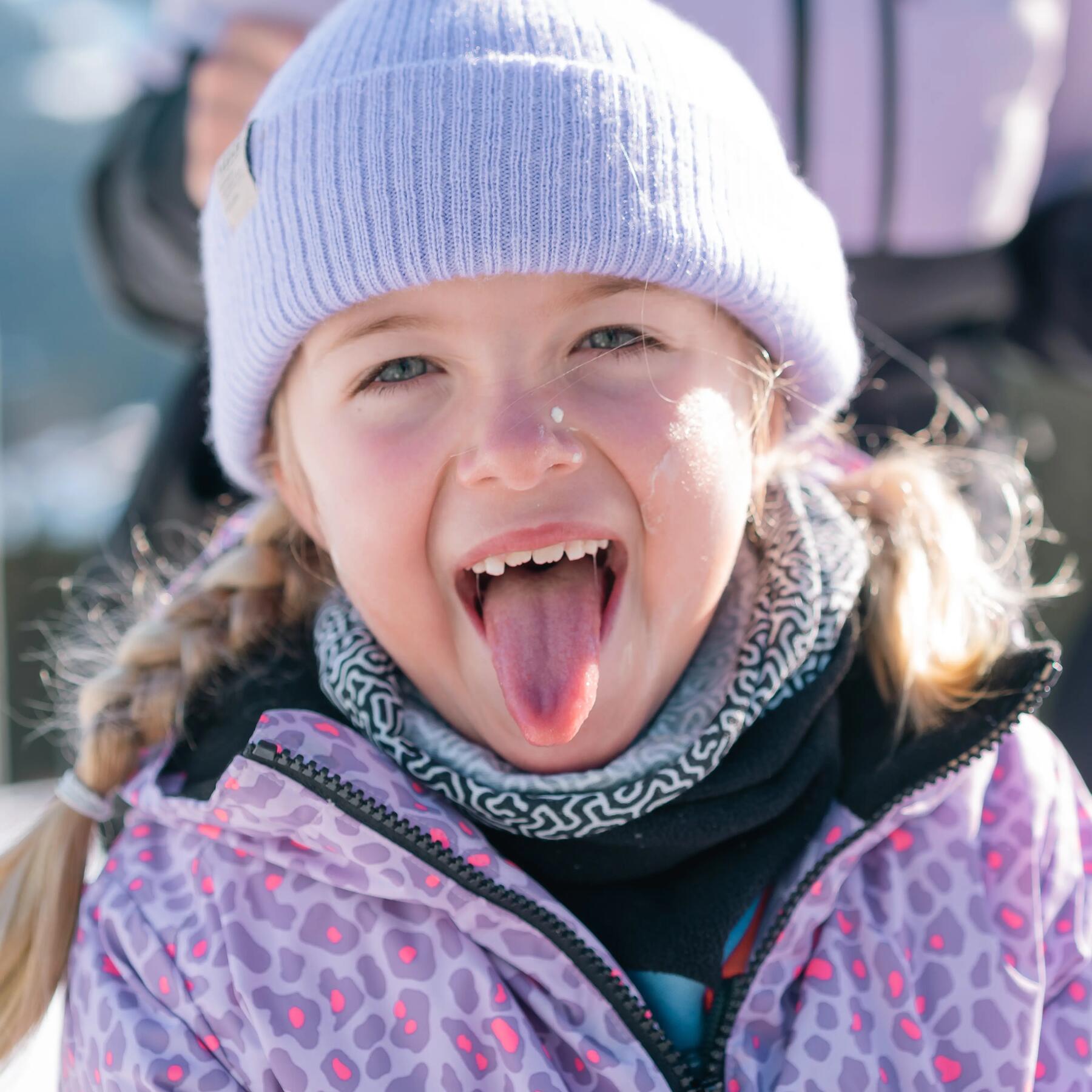 petite fille qui tire la langue en tenue de ski decathlon