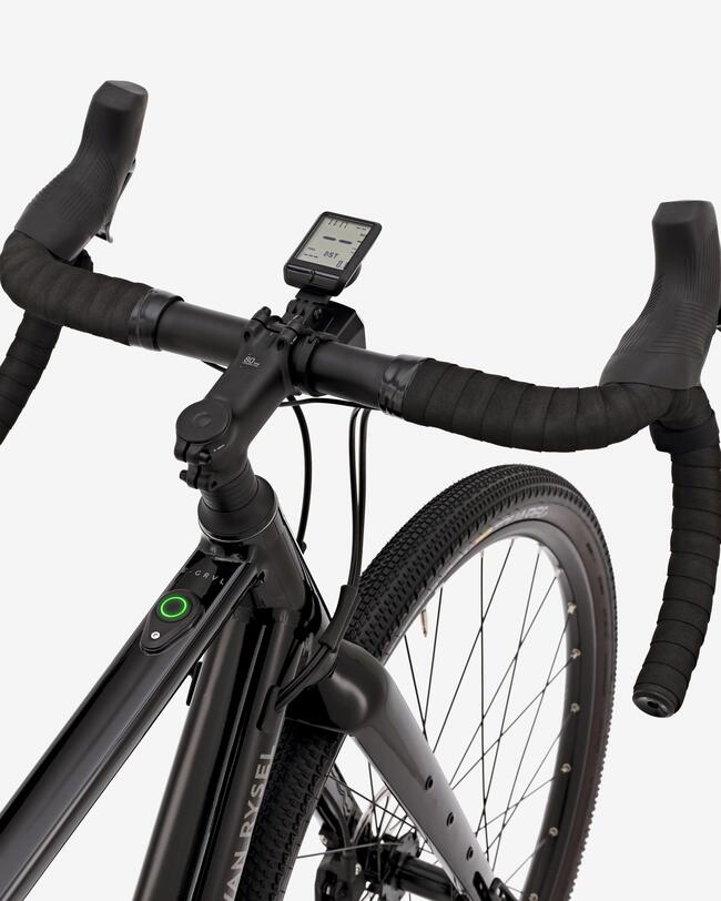 Schwarzer Fahrradlenker mit gewellten Griffen, digitalem Display und grobprofiligem Reifen vor grauem Hintergrund.