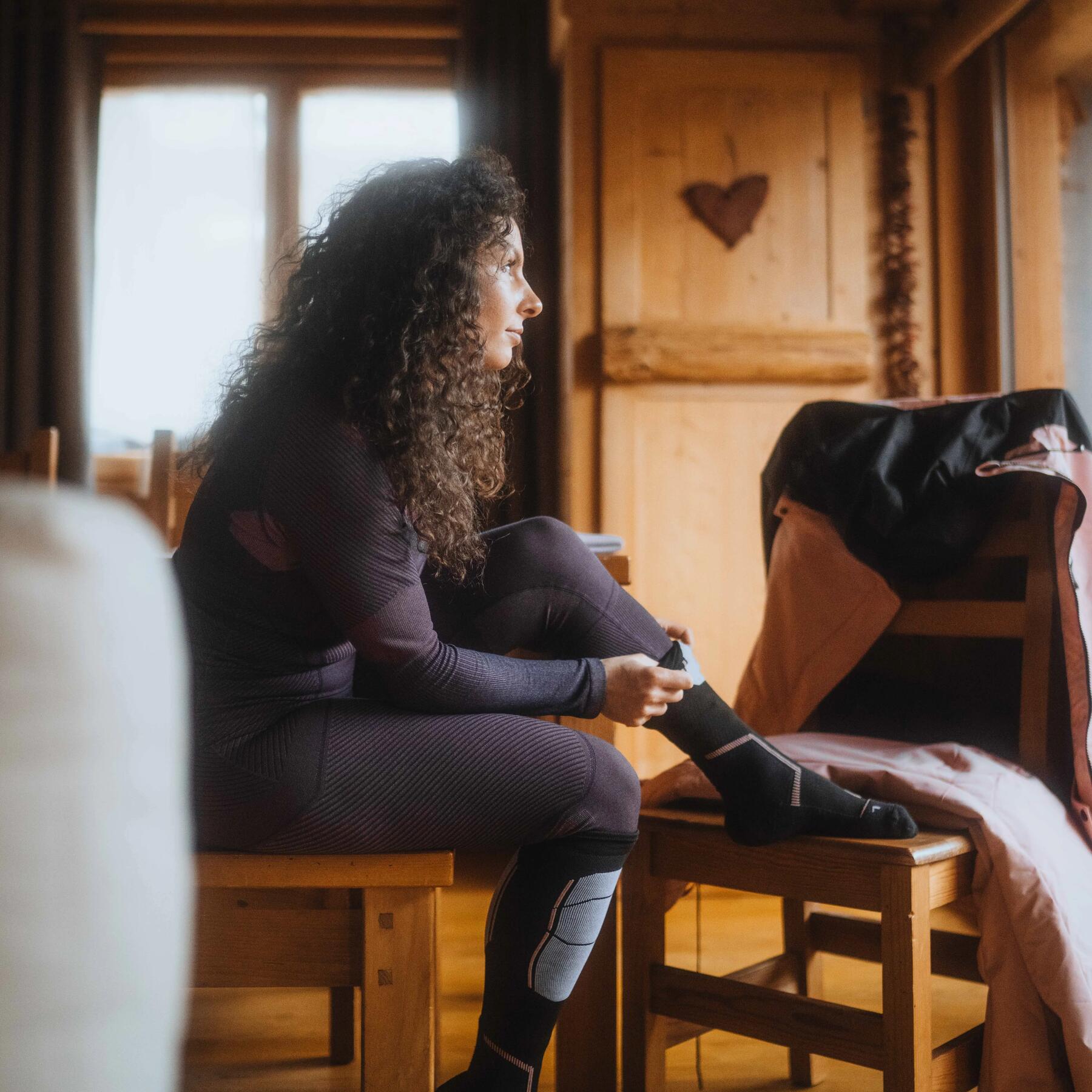 femme qui met une chaussette de ski decathlon quechua