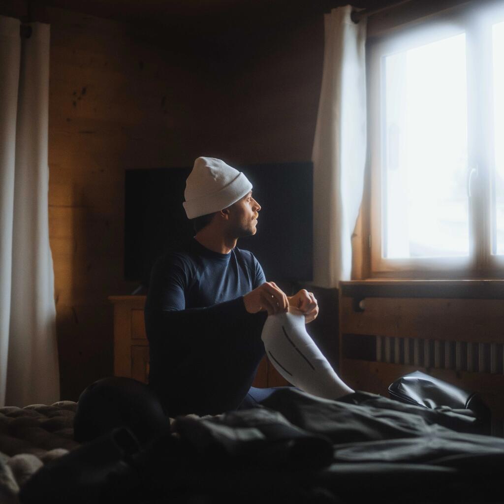 Mann auf Bett mit Skisocken