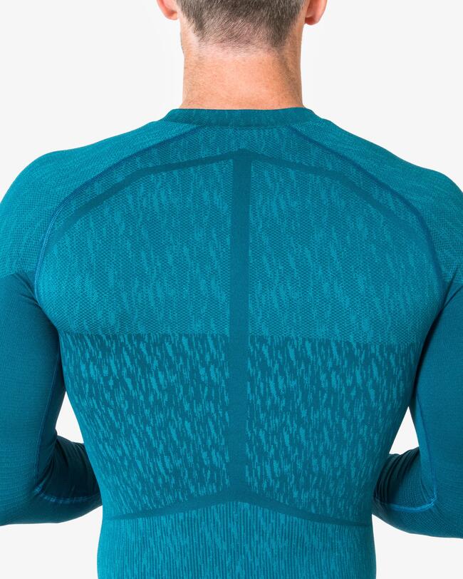 Mann von hinten trägt blaues Keepdry-Shirt vor weißem Hintergrund. Technische Details sichtbar.