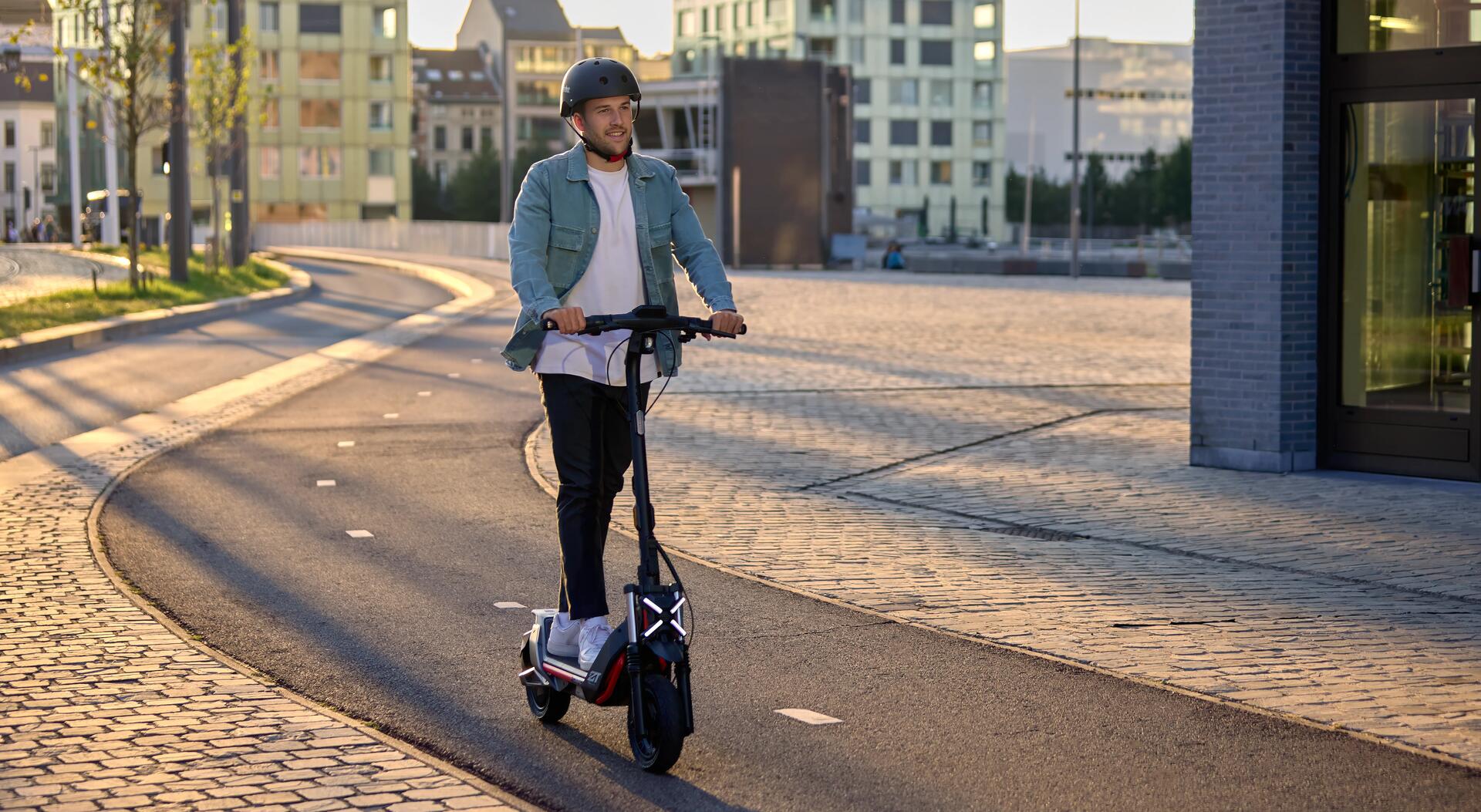 Homem a andar de trotinete na cidade