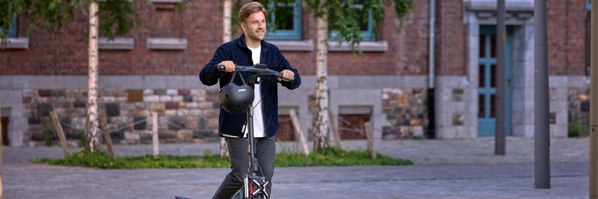 Mężczyzna prowadzący hulajnogę elektryczną