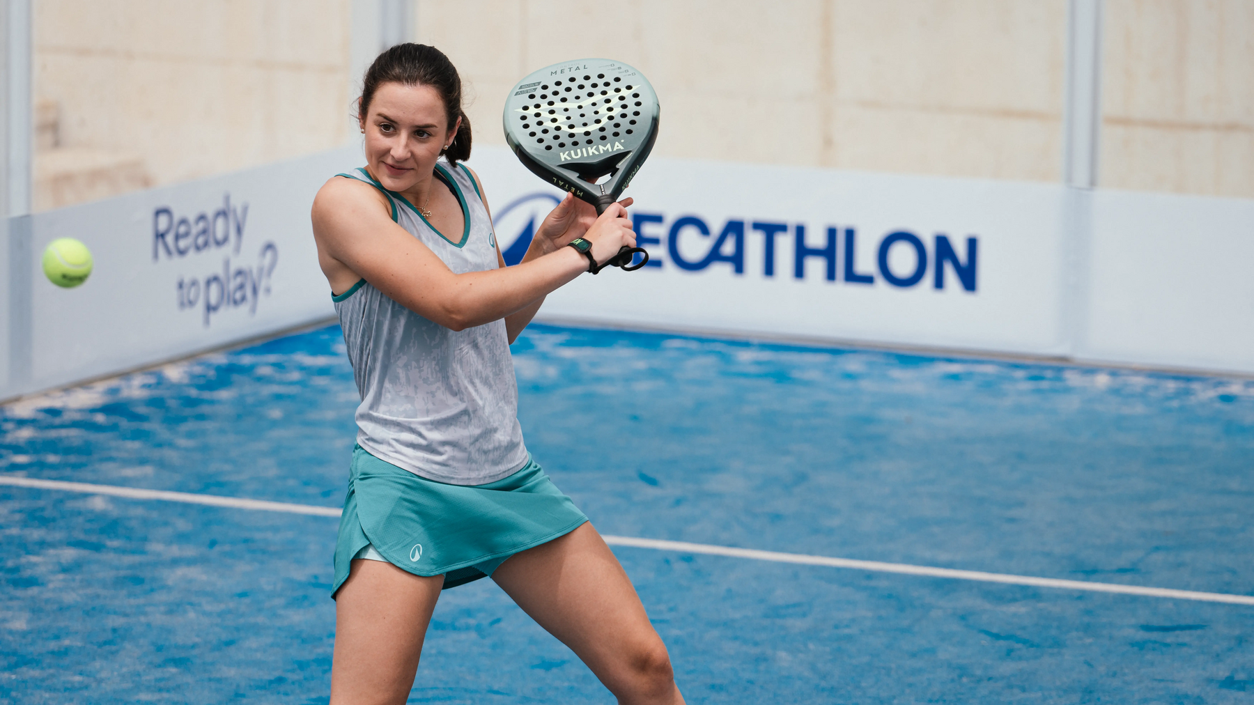 Eine Padelspielerin schlägt den Ball während eines Spiels auf dem Padelcourt