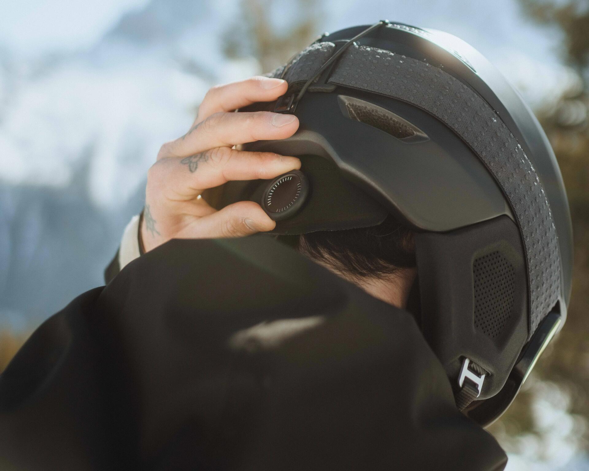 Mann hält sich den Skihelm
