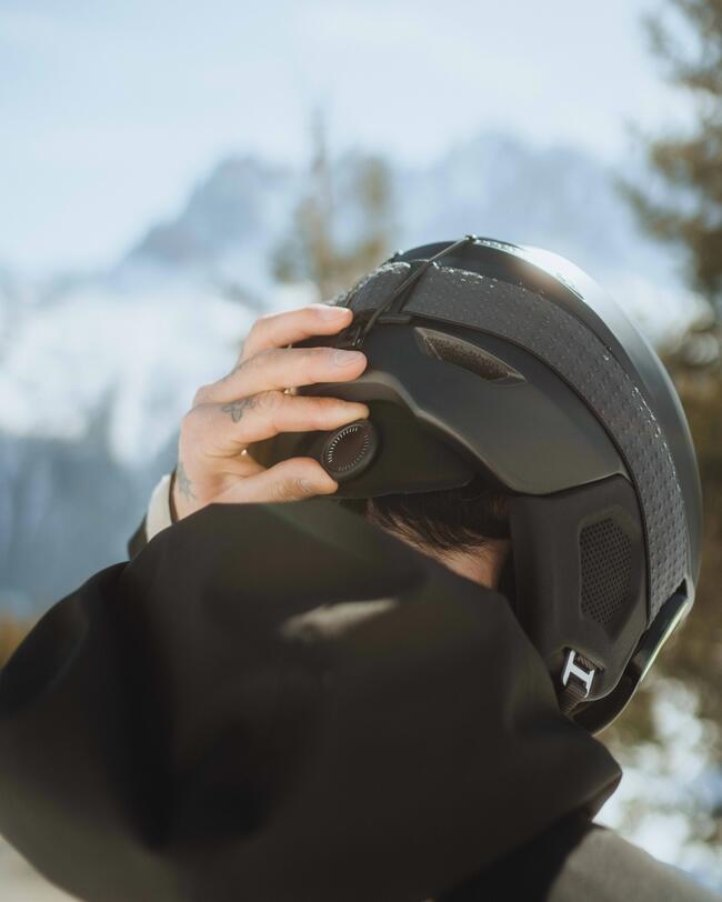 Mann hält sich den Skihelm 