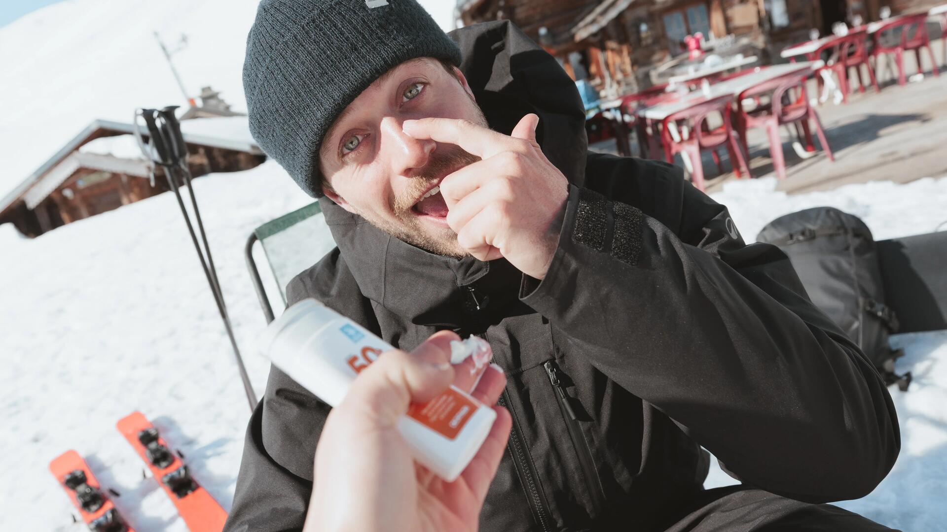 Homme appliquant de la crème solaire sur son visage