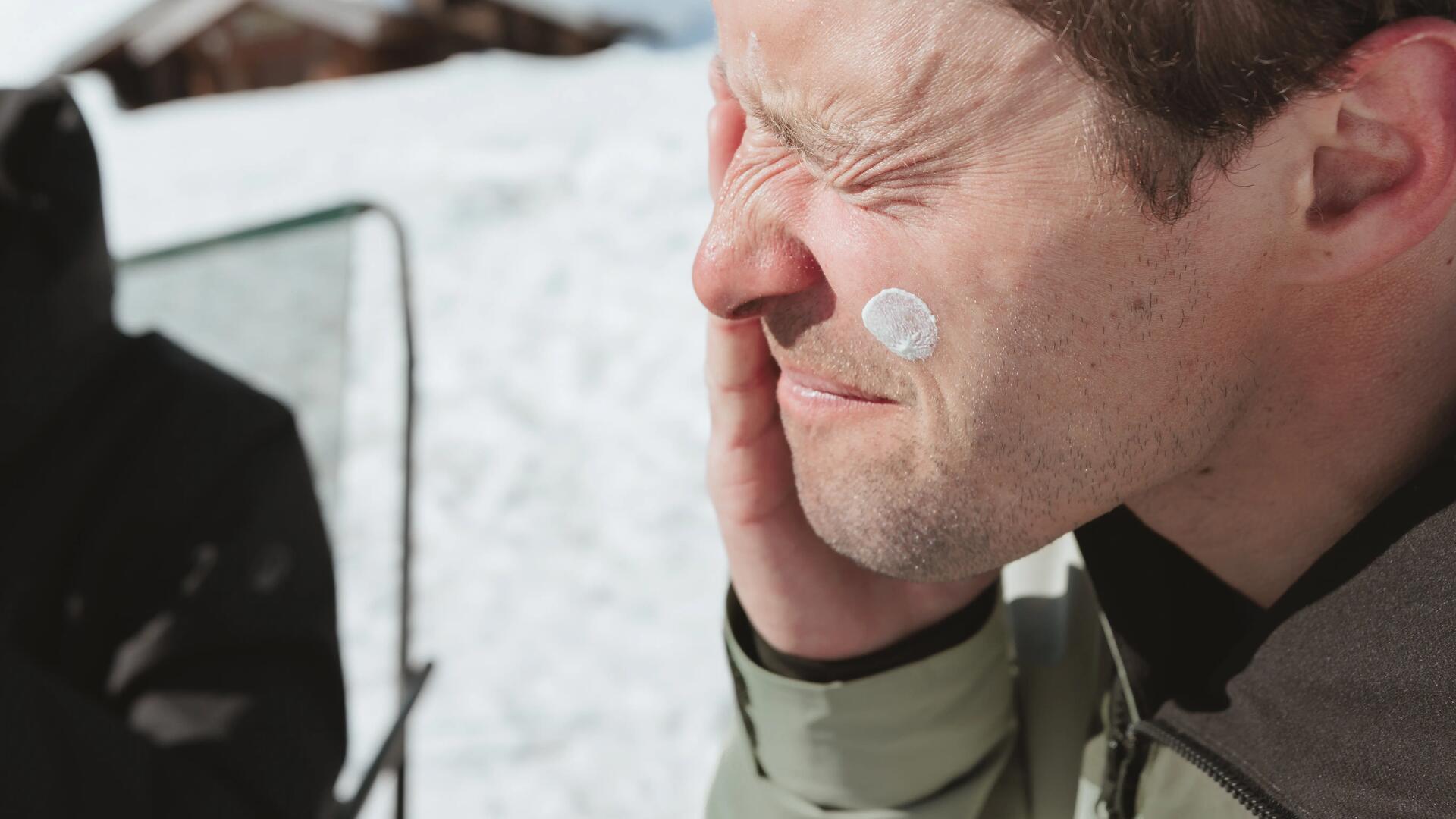 Homme appliquant de la crème solaire sur son visage