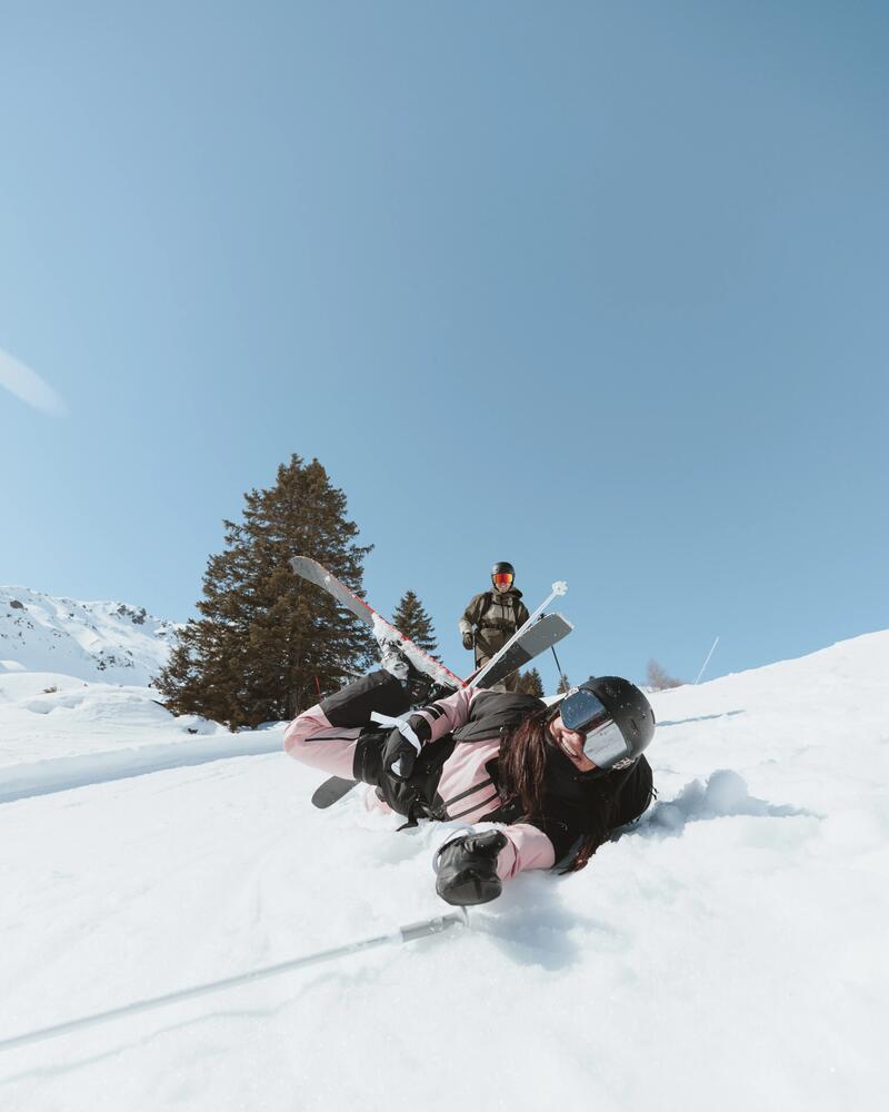 Skifahrer mit Helm liegt auf der Piste