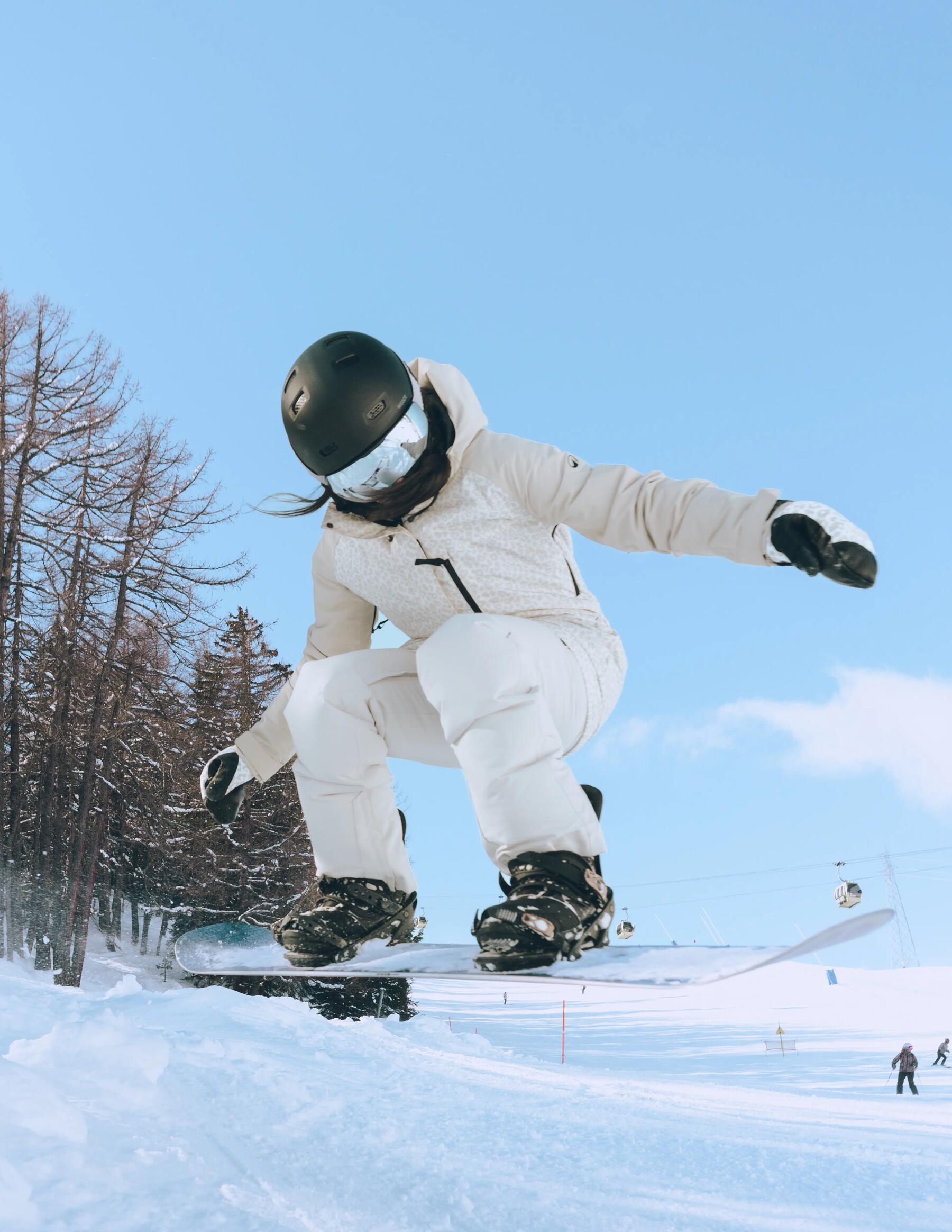 Planchiste devant une cabane avec sa planche à la main